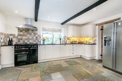 Modern well-equipped kitchen with granite work top and slate flooring